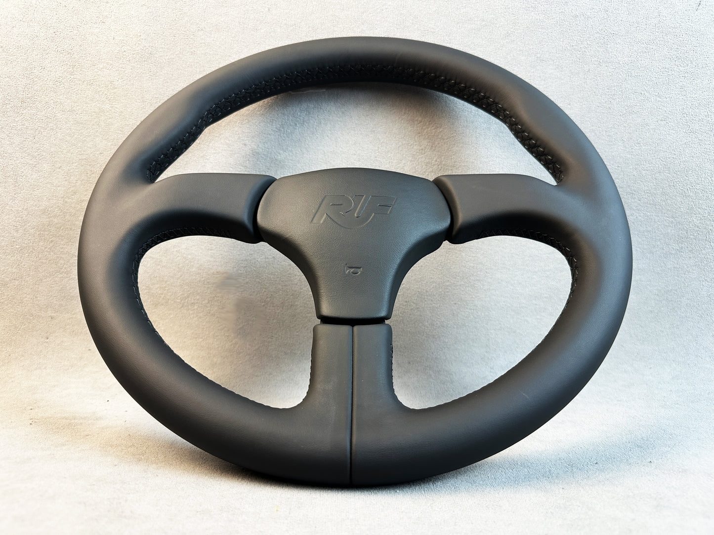 Close-up on stitched leather detail of Atiwe 32 steering wheel