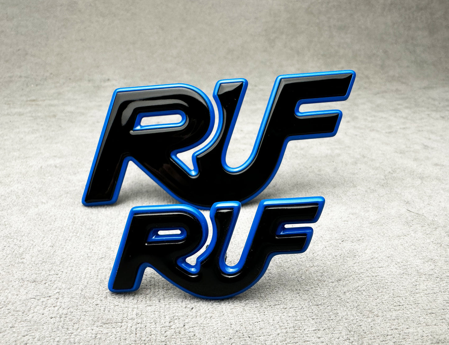 Porsche 997 with installed black and blue RUF metal emblem for performance styling