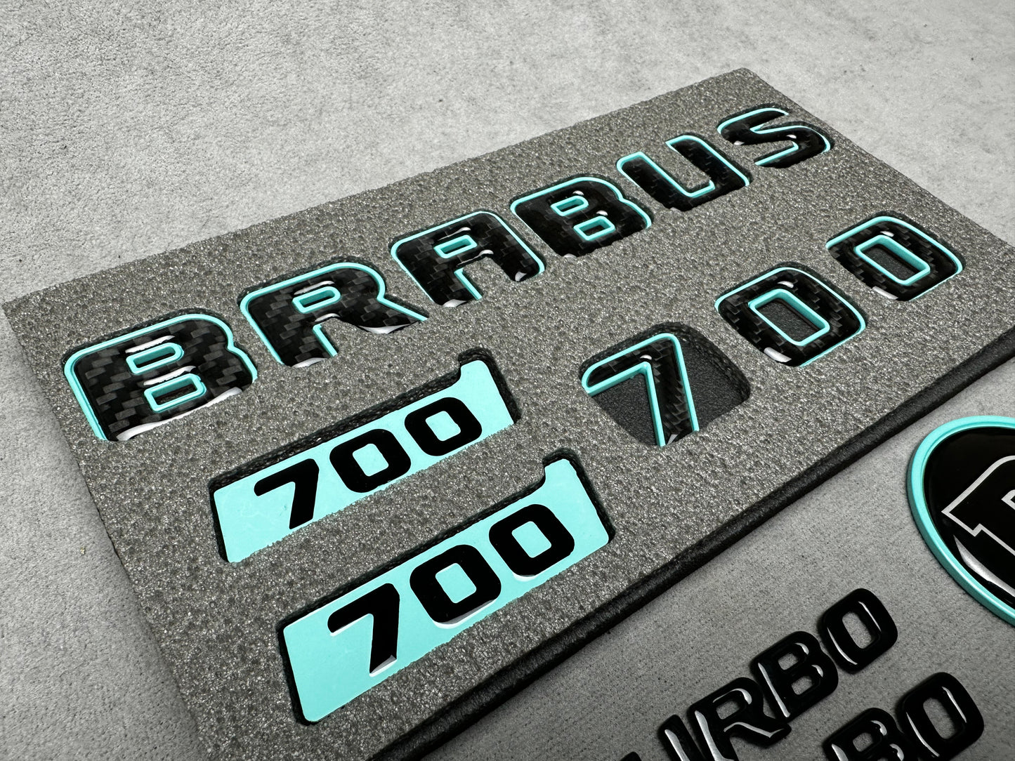 Brabus 700 Tiffany Blue with Carbon exterior emblems set for G-Wagon W463A W465, including trunk, Biturbo side badges, round B for hood, and Brabus insertions
