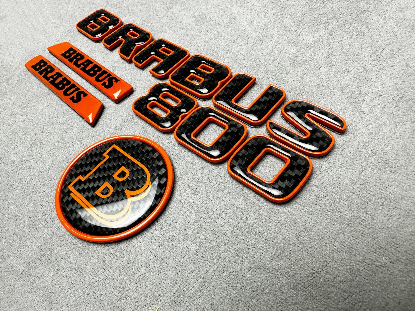 Brabus 800 orange metallic emblem badge with carbon fiber accents for Mercedes G-Wagon W463A, premium exterior upgrade