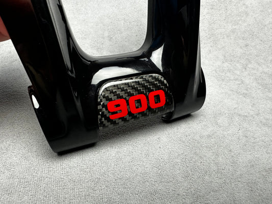 Close-up of Brabus 900 flat carbon steering wheel emblem badge with "900" sign on Mercedes interior