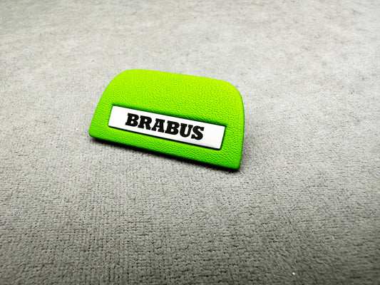 Close-up of Brabus green emblem with metal insert on a Mercedes steering wheel