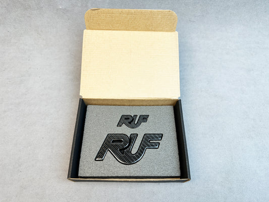 Gloss black carbon RUF badge close-up