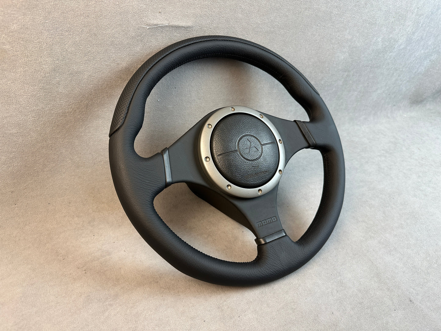 Close-up of leather-wrapped airbag cover on MOMO Evo wheel