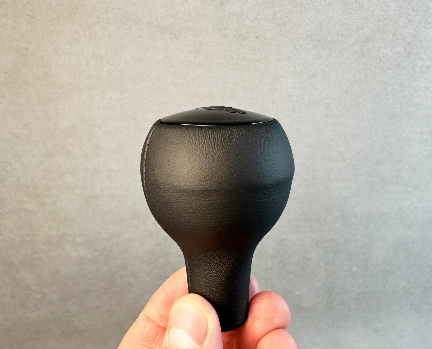 Side profile of RUF leather gear knob with subtle matte logo