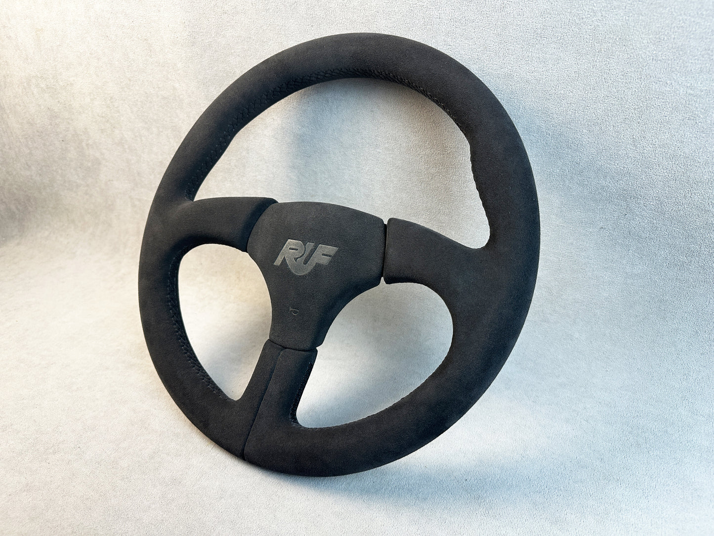 Close-up of grey stitching on Alcantara RUF steering wheel