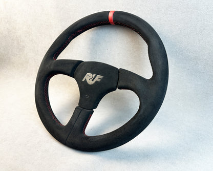 Close-up of Alcantara grip and red stitching