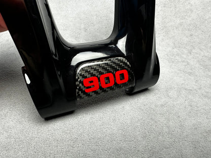 Close-up of Brabus 900 flat carbon steering wheel emblem badge with "900" sign on Mercedes interior