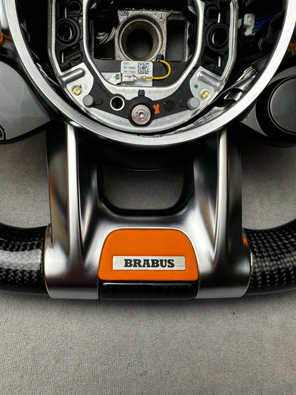Close-up of Brabus Orange flat leather emblem on a Mercedes steering wheel