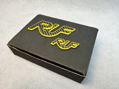 Motorsport-styled RUF carbon badge with yellow overlay