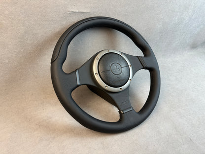 Close-up of leather-wrapped airbag cover on MOMO Evo wheel