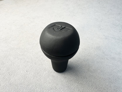 Close-up of RUF logo on black leather shift knob